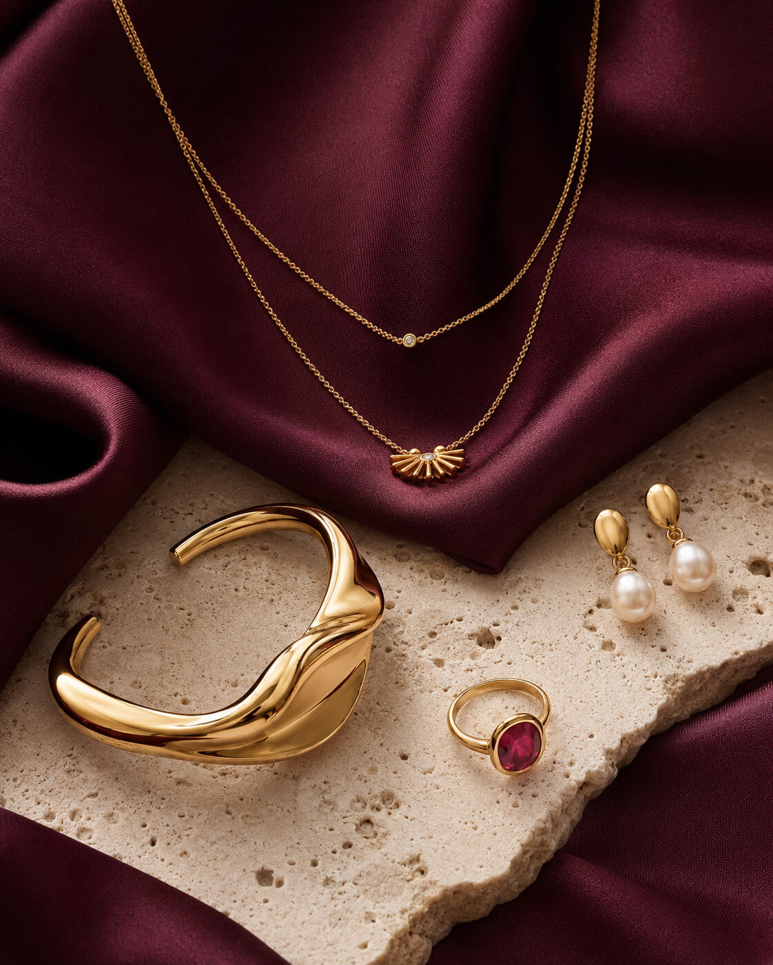 HavaPassion gold jewelry on plum silk and travertine